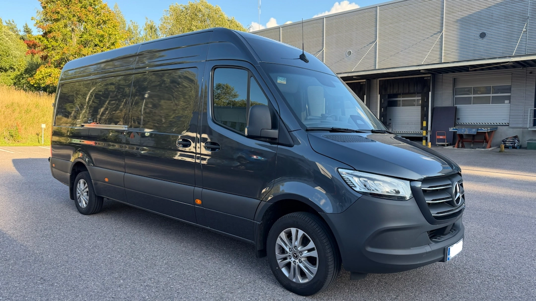 Tumma pakettiauto terminaalin edustalla